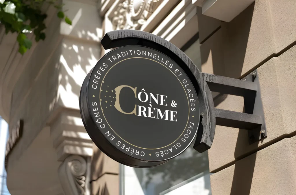 Un panneau sur un bâtiment qui présente le logo de Cône & Crème